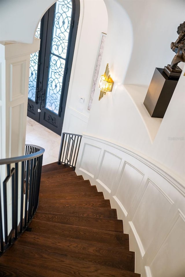 570 Manor Rd, Maitland, FL 32751 - stairs featuring arched walkways, french doors, wood finished floors, and a decorative wall