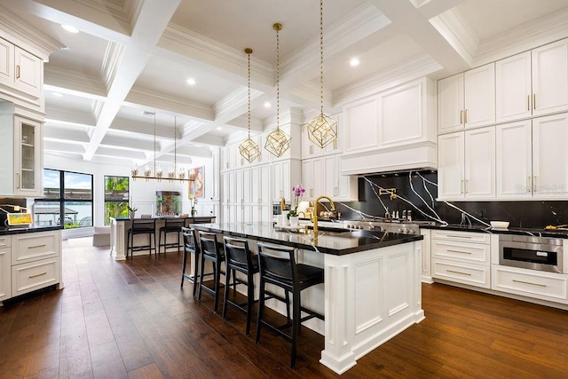 570 Manor Rd, Maitland, FL 32751 - kitchen featuring coffered ceiling, backsplash, dark countertops, a breakfast bar, and beam ceiling