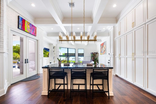 570 Manor Rd, Maitland, FL 32751 - kitchen with an inviting chandelier, dark countertops, ornamental molding, beamed ceiling, and a decorative wall