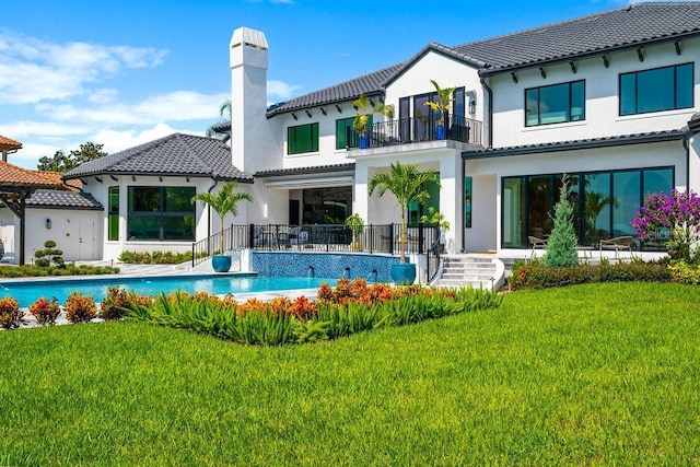 570 Manor Rd, Maitland, FL 32751 - rear view of property featuring a balcony, an outdoor pool, a tiled roof, a yard, and stucco siding