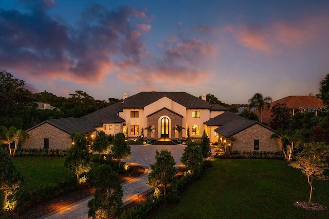 570 Manor Rd, Maitland, FL 32751 - mediterranean / spanish-style house featuring a lawn, stone siding, a chimney, and stucco siding