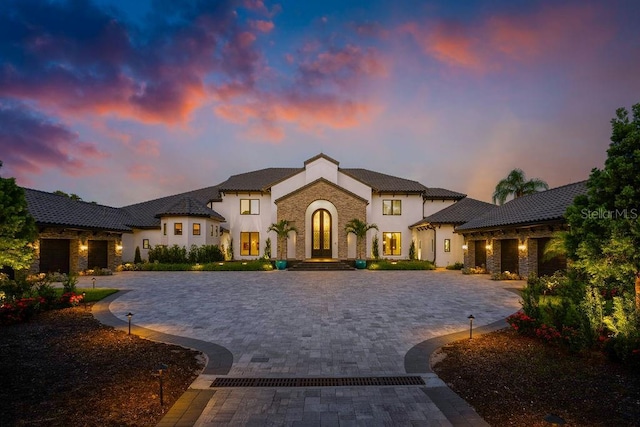 570 Manor Rd, Maitland, FL 32751 - french country inspired facade featuring stone siding, french doors, curved driveway, and stucco siding