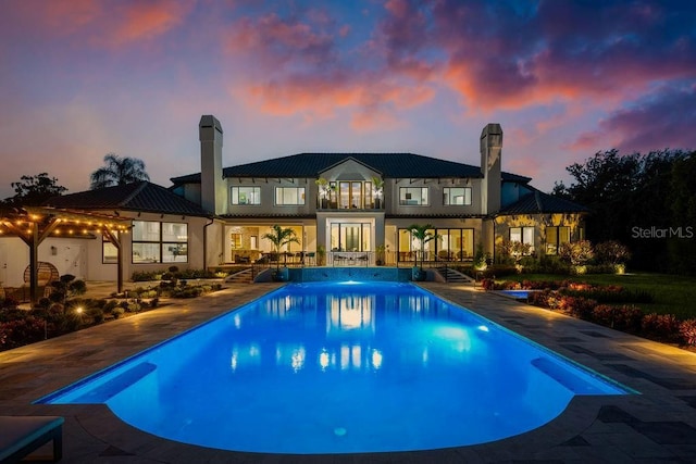 570 Manor Rd, Maitland, FL 32751 - back of house featuring an outdoor pool, a patio, a chimney, and metal roof