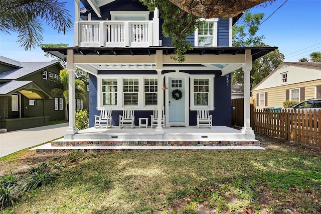 back of property with covered porch and a balcony
