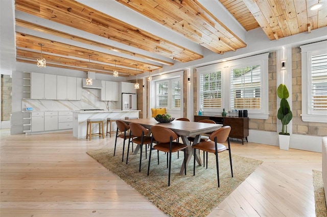 dining room featuring beamed ceiling, wood ceiling, and light wood-style flooring