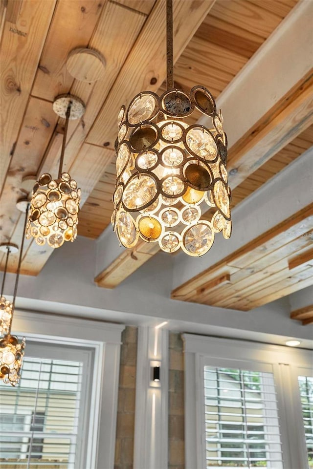 detailed view of a chandelier, wooden ceiling, and beam ceiling