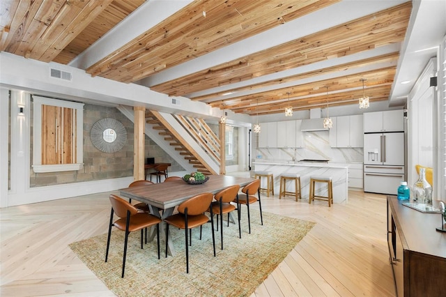 dining room featuring stairway and beamed ceiling