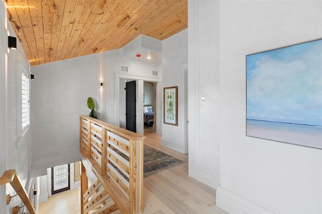 hall featuring wood ceiling, an upstairs landing, light wood finished floors, and high vaulted ceiling