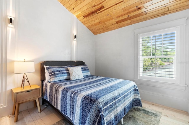bedroom with lofted ceiling, light wood-style floors, and wooden ceiling