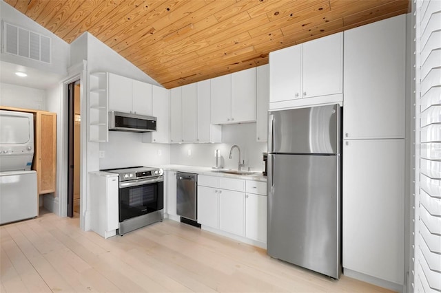 kitchen with appliances with stainless steel finishes, stacked washing machine and dryer, wooden ceiling, a sink, and light countertops