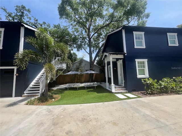 view of front facade with stairway and stucco siding