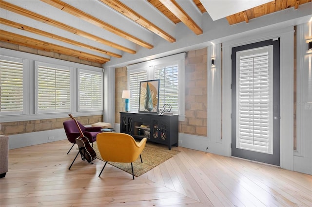living area featuring beam ceiling and wood-type flooring