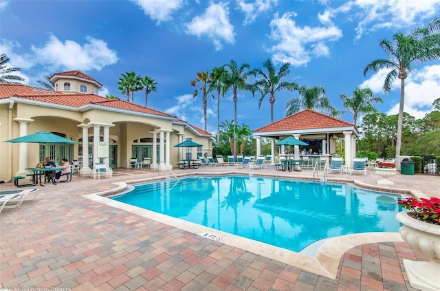 pool with a gazebo, fence, and a patio area