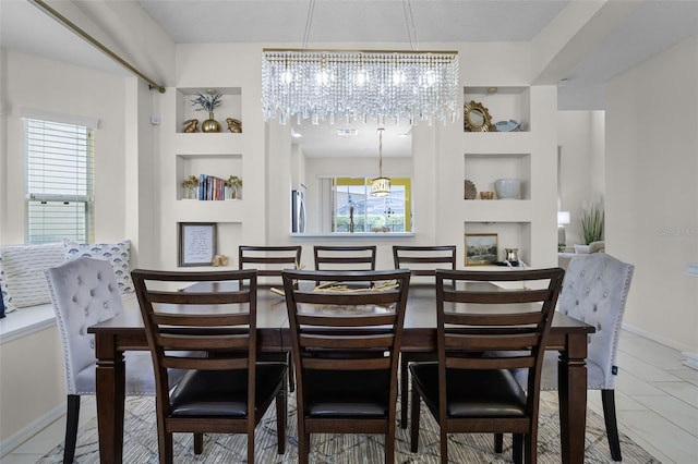 dining space featuring an inviting chandelier, baseboards, and built in shelves