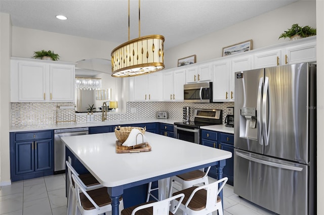 kitchen with light countertops, blue cabinetry, white cabinetry, and stainless steel appliances