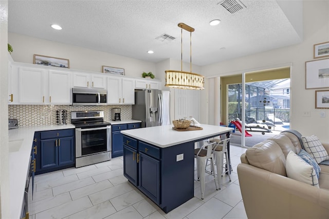kitchen with stainless steel appliances, blue cabinetry, open floor plan, and visible vents
