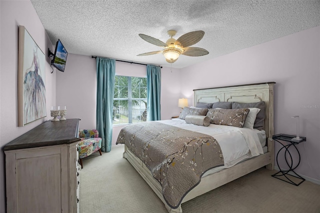 bedroom featuring a textured ceiling, carpet, and a ceiling fan