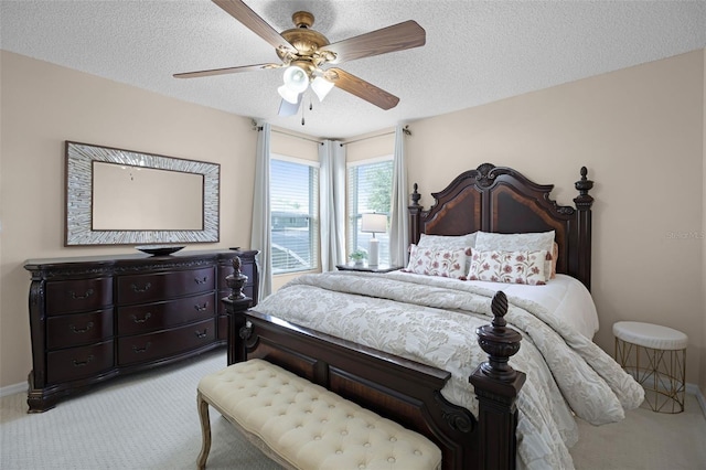 carpeted bedroom featuring baseboards, ceiling fan, and a textured ceiling