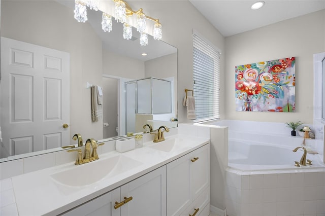 bathroom featuring double vanity, a sink, a garden tub, and a stall shower