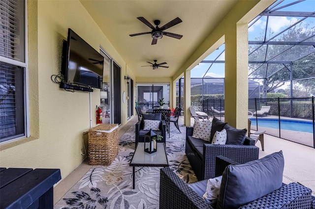 view of patio / terrace featuring glass enclosure, outdoor lounge area, a ceiling fan, and a fenced in pool
