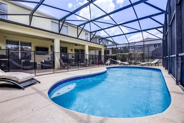 pool with glass enclosure, ceiling fan, and a patio area