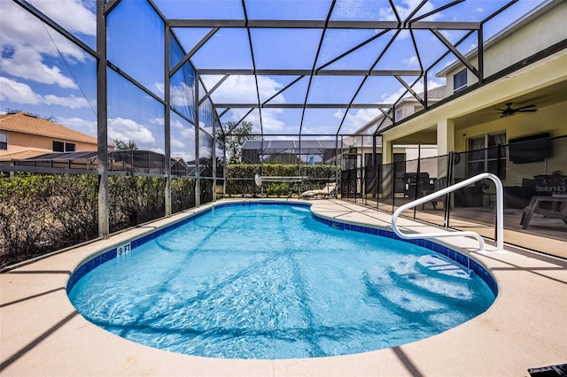 pool with a ceiling fan, glass enclosure, and a patio area