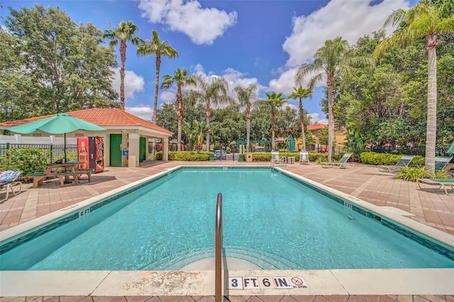 community pool with a patio and fence