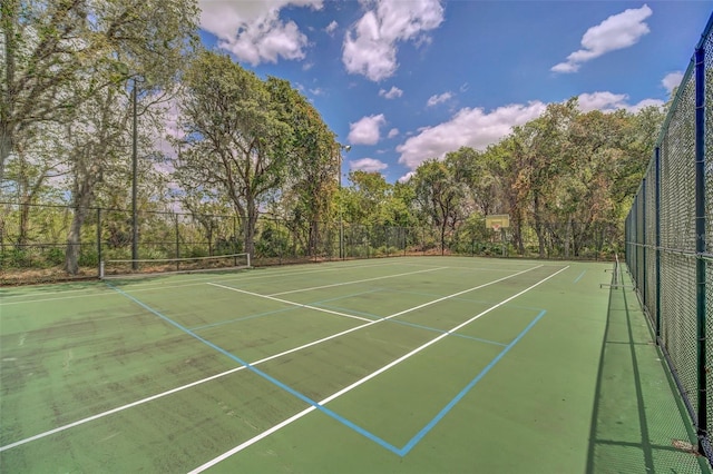 view of tennis court featuring fence