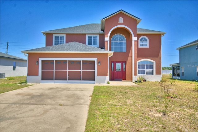 traditional-style house with a garage, a front lawn, stucco siding, and concrete driveway