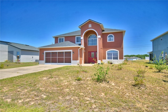 view of front of home with stucco siding, concrete driveway, a front yard, and a garage