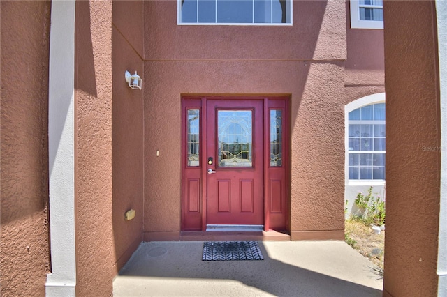 doorway to property featuring stucco siding