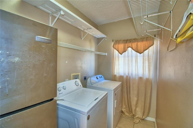 washroom with tile patterned flooring, washing machine and clothes dryer, and laundry area