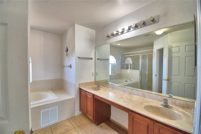 bathroom featuring tile patterned floors, a garden tub, visible vents, and a sink