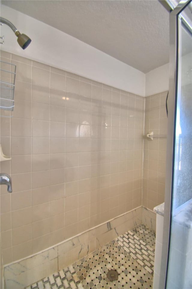 bathroom featuring a textured ceiling and a shower stall
