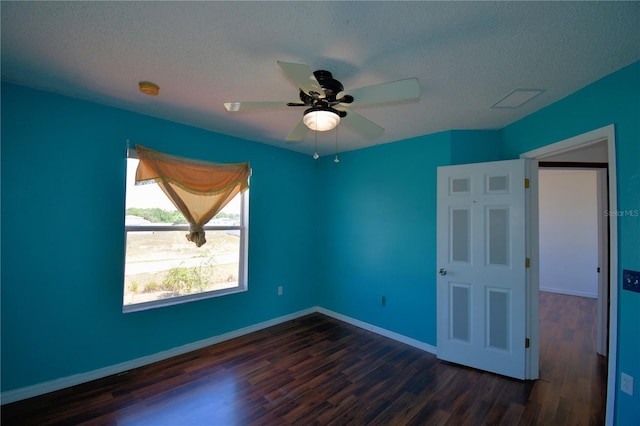 unfurnished room with visible vents, dark wood-type flooring, baseboards, a textured ceiling, and ceiling fan