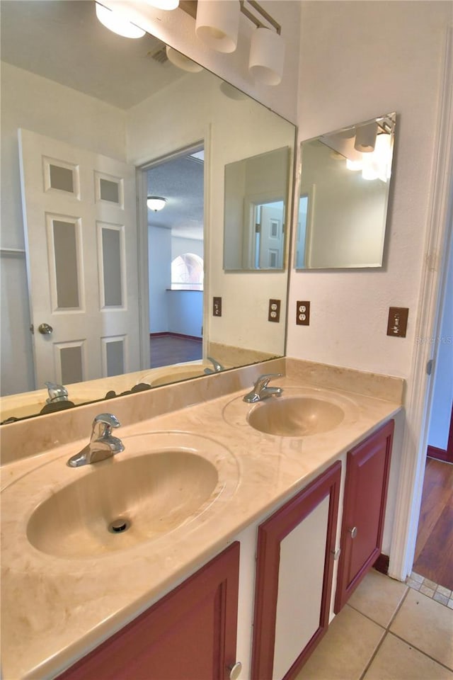 bathroom with tile patterned flooring, visible vents, a sink, and double vanity