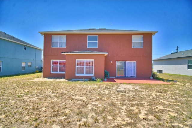 back of house featuring stucco siding, a patio area, cooling unit, and a lawn