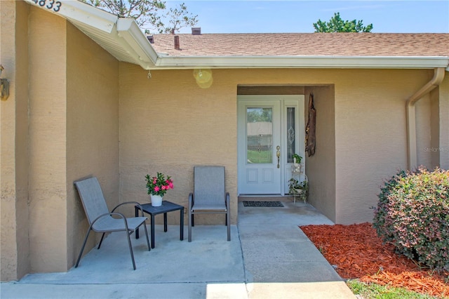 4833 Palm Tree Ct, Windermere, FL 34786 - entrance to property with a patio, stucco siding, and a shingled roof