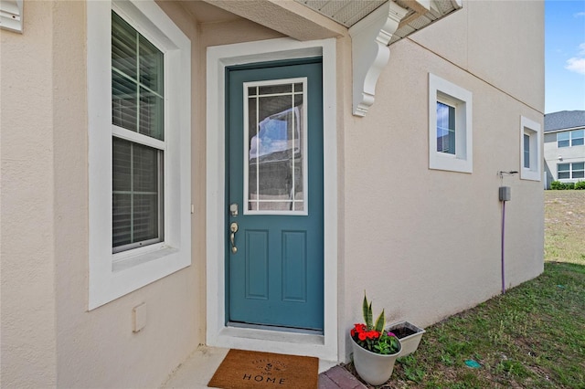 property entrance with stucco siding