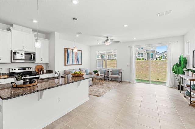 kitchen featuring a healthy amount of sunlight, light tile patterned floors, a sink, and appliances with stainless steel finishes