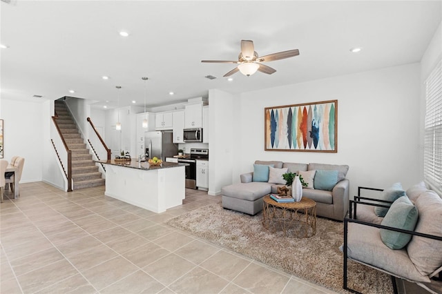 living room with light tile patterned floors, baseboards, ceiling fan, stairway, and recessed lighting