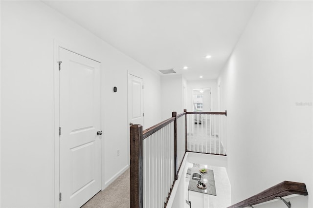 hallway featuring visible vents, recessed lighting, light carpet, an upstairs landing, and baseboards