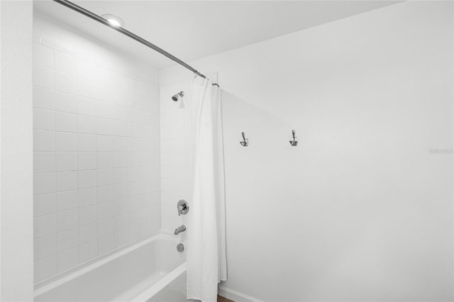 bathroom with shower / bath combination with curtain and baseboards