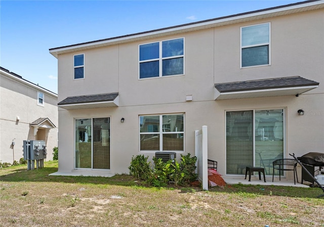 back of property featuring roof with shingles, stucco siding, central air condition unit, a patio area, and a lawn