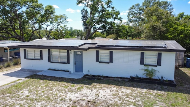 single story home featuring fence and solar panels