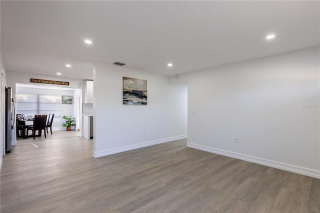 interior space with recessed lighting, wood finished floors, visible vents, and baseboards
