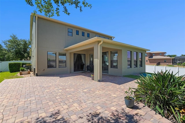 4113 Longbow Dr, Clermont, FL 34711 - rear view of property featuring a fenced backyard, a patio area, and stucco siding