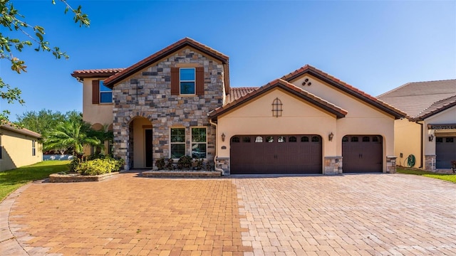 8625 Brixford St, Orlando, FL 32836 - mediterranean / spanish-style house featuring stone siding, a garage, a tile roof, stucco siding, and driveway