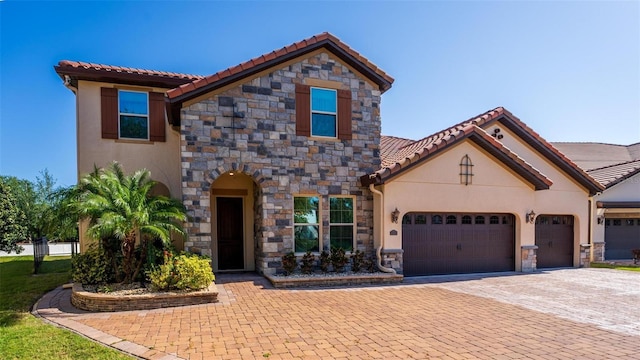 8625 Brixford St, Orlando, FL 32836 - mediterranean / spanish home featuring an attached garage, stucco siding, stone siding, and decorative driveway