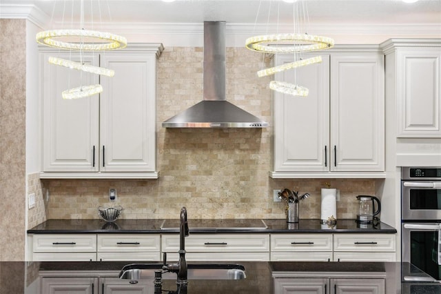 8625 Brixford St, Orlando, FL 32836 - kitchen with black electric stovetop, wall chimney range hood, dark countertops, white cabinets, and double oven